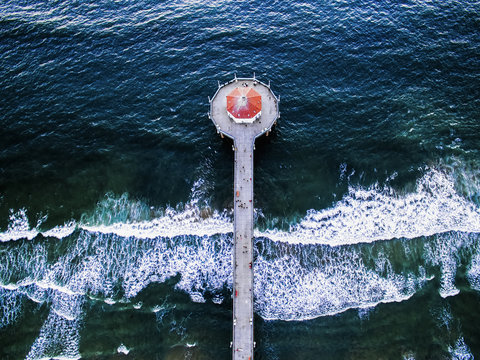 Aerial view of the Manhattan Beach Pier and waves breaking on the shore. 