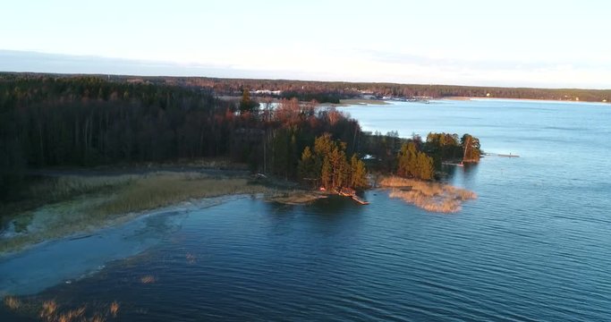 Cinema 4k aerial view of a wooden pier, in koivuniemi or bj&ouml;rkudden in Inkoo, at a sunset evening, in the finnish archipelago, of Finland