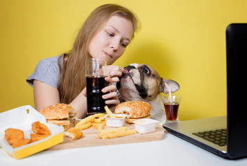 Girl and dog eating fast food