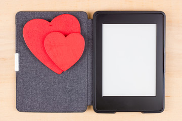 Card for Valentine's Day with two red hearts on e-book reader with copy space on screen