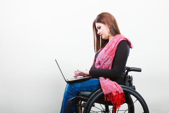 Disabled woman with laptop on wheelchair.