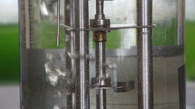 Laboratory  fermenter (bioreactor) works filled with water. Air bubbles are important for bacteria aspiration. Steel impeller agitates liquid to obtain necessary mass-transfer. Vertical panning up.
