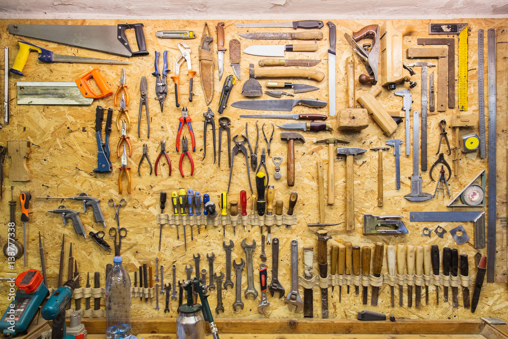 Wall mural work tools hanging on wall at workshop