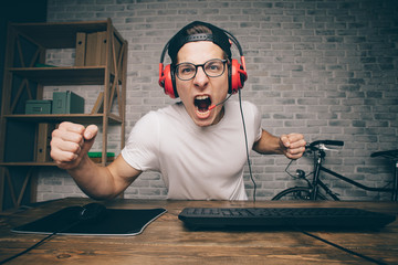 Young man playing game at home and streaming playthrough or walkthrough video