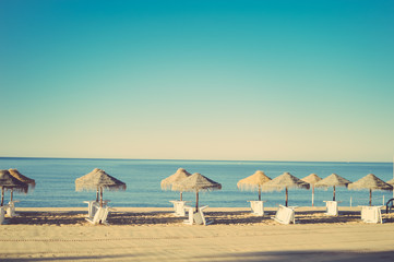 Holiday and vocation image with beach lounge and parasol on ocean sea outdoors sunny background