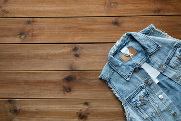 close up of denim waistcoat with price tag on wood