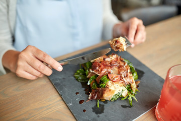 woman eating prosciutto ham salad at restaurant