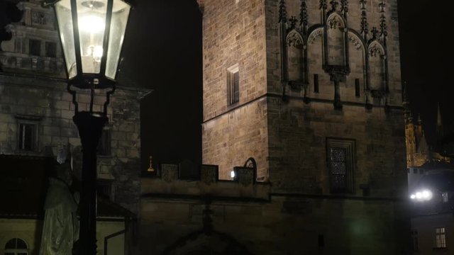 At night gothic archtecture of Charles bridge over Vltava river in Czech Republic capital slow tilt 2160p UltraHD video - Tilting on Lesser Town tower in Czechia city of Prague 3840X2160 UHD footage 