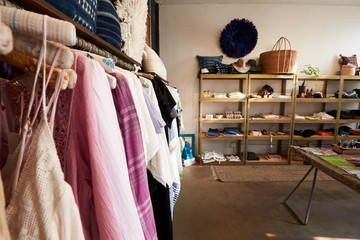 Clothes hanging on a rail in a clothes and accessories shop