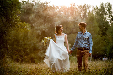 Couple on the nature, the bride and groom hugging at the wedding.