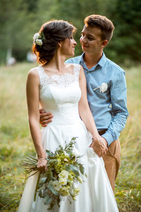 Couple on the nature, the bride and groom hugging at the wedding.