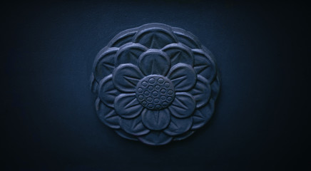 Dark stone flower emblem ornament