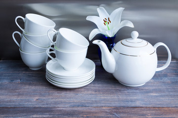 Fototapeta na wymiar White porcelain tea set - stacked cups and saucers and tea pot.