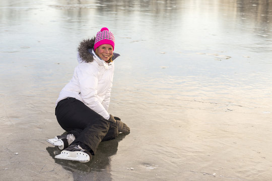 Woman sitting on the ice skating.