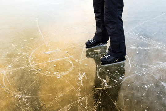 The ice skating tracks, a man stands beside her.