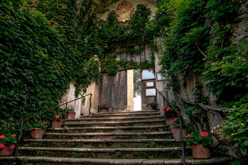 Fototapeta na wymiar Striscia di luce cade sulla scala tra le mura, invasi dalla vegetazione, che porta al parco della villa Cimbrone sulla Costiera Amalfitana