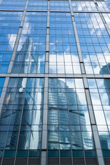 skyscrapers of steel and glass reflected in buildings facade