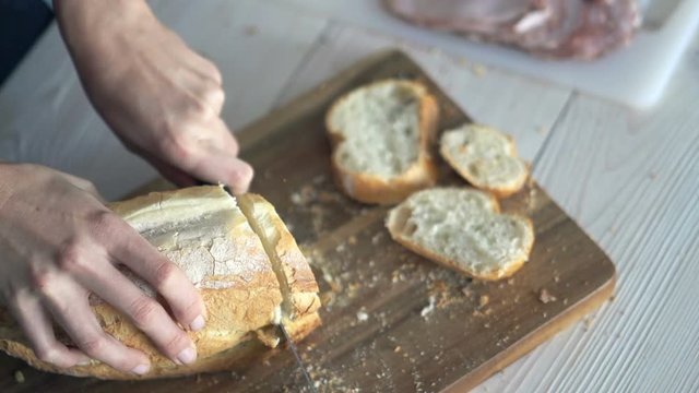 Female hands slicing white bread, top view, super slow motion 240fps
