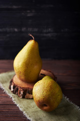 Two fresh green pears on a rustic background with napkin. Vertical shot