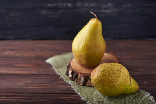 Two fresh green pears on a rustic background with napkin