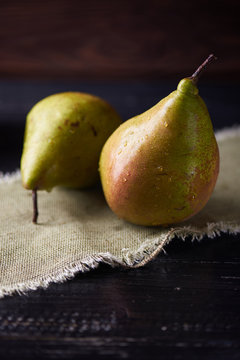 Fresh green pears on a rustic background on a napkin. Vertical shot