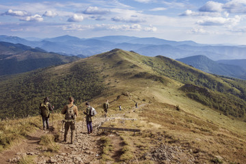 Grupa paramilitarnych ludzi idzie po szlaku w górach Bieszczady - obrazy, fototapety, plakaty
