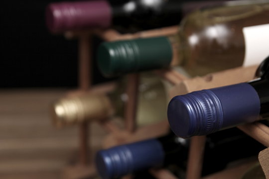 Various red and white wine bottles in a wooden wine rack