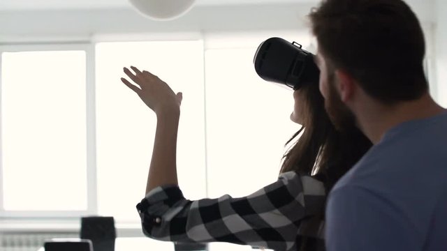 Young happy ouple having fun playing with virtual reality glasses