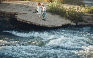 the bride and groom on the background of a mountain stream