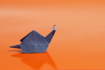 Paper origami snail isolated on a colorful background