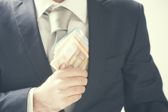Businessman putting money in his pocket