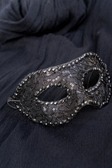 View of festive mask on black silk background