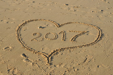 Peace sign in a 2017 heart on the beach