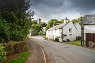 Fototapeta na wymiar Street view with an old cottage and the church in the picturesque village Altarnun in north Cornwall.