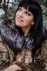 Portrait of a happy woman in a coat on a walk in the park. smiling woman is walking in the winter city
