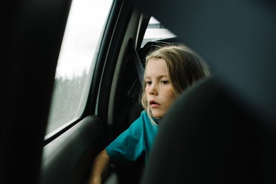 Boy looking out through window while travelling in car