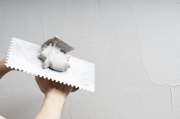 Hands Plasterer at work. Application of the plaster on the wall.