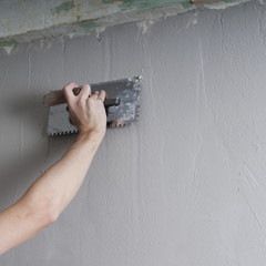Hands Plasterer at work. Application of the plaster on the wall.