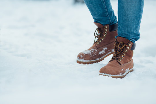 Men's winter boots on snow. Brown men's warm winter boots closeup