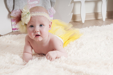 Baby girl playing on the carpet at home or kindergarten