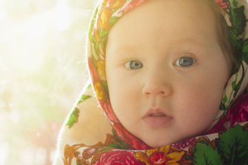 Portrait of a pretty little girl in a traditional Russian scarf