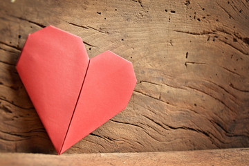 Valentine's day red paper origami heart on wooden background