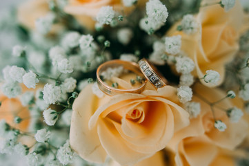 Bouquet of yellow roses and wedding rings