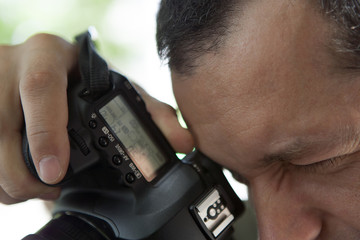 Man using camera, looking through viewfinder