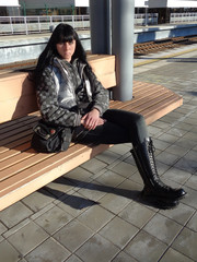 Young woman sitting on bench at the platform waiting for train