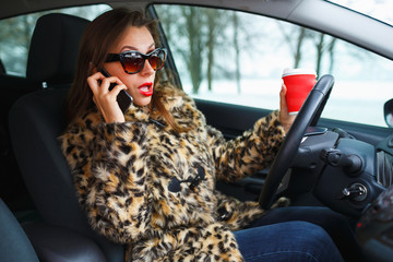 Businesswoman multitasking while driving, drinking coffee and ta