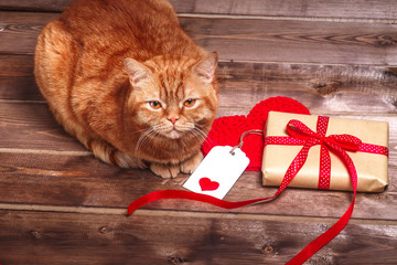 Naklejka premium Wrapped vintage gift box with red ribbon bow and gift card on the wooden table can use on valentine day mother day or celebrate love day .Red cat