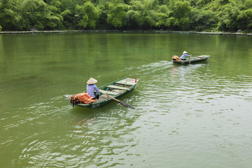 Fototapeta na wymiar Vietnamese woman rowing boat on river