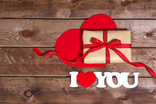 gift and the words "I love you" on a wooden background . Valentines day red heart. Red heart set. Valentine day card.