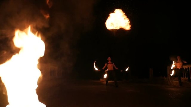 Fantastic Show at Sunset. Circus on Stilts Spit the Fire. the Action in Slow Motion.